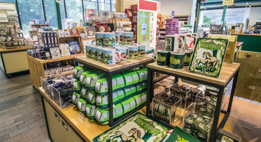 A display of New Forest branded mugs, tea towels and keyrings in the Beaulieu gift shop