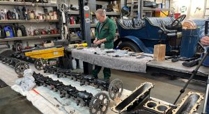 Workshop engineer Mitch Caws works on parts of Sunbeam's second engine laid out in the National Motor Museum workshop