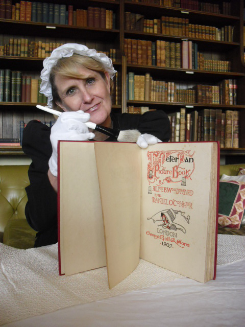 A Palace House guide conserves a library book