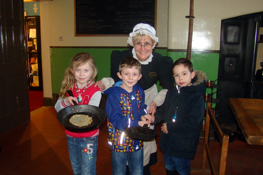 Children with Mrs Hales in Palace House. Taking part in the pancake tossing competition.